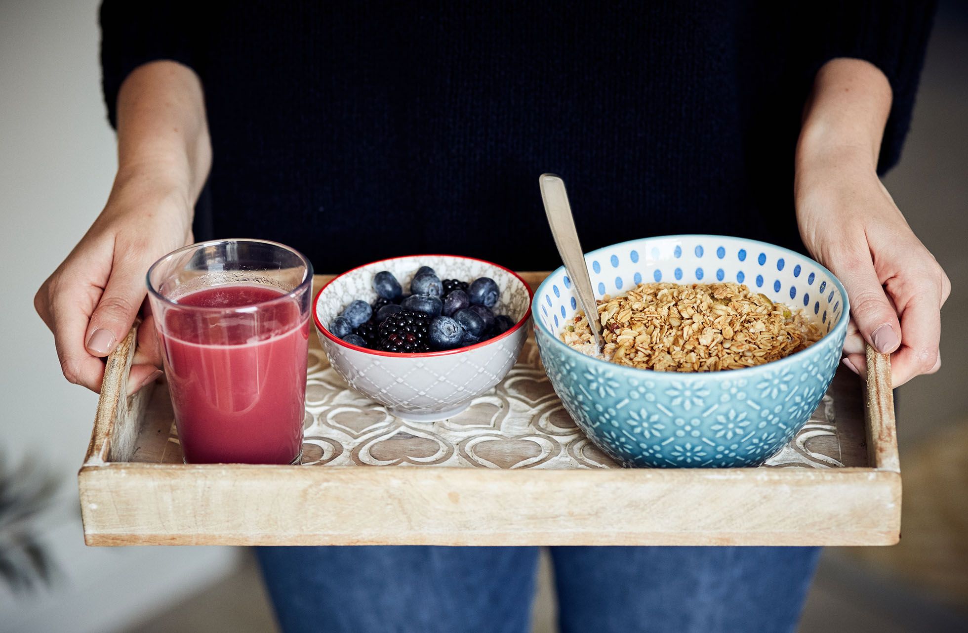 Woman holding breakfast tray of fresh healthy food